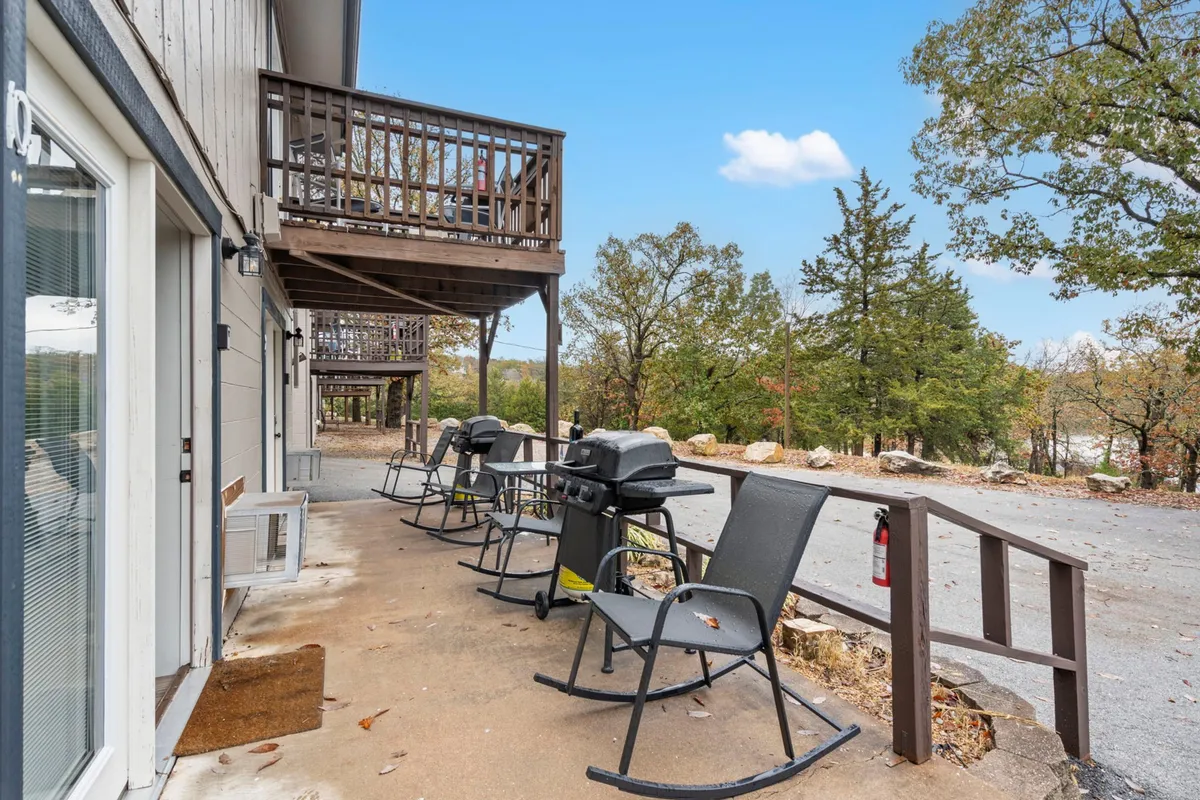 A porch with wooden rocking chairs facing open green space and trees, evoking a peaceful setting for morning coffee or sunset conversations.